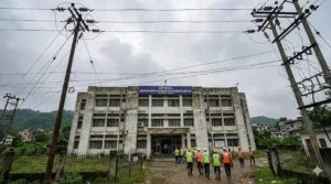 APDCL office building in Assam with power lines and staff in front