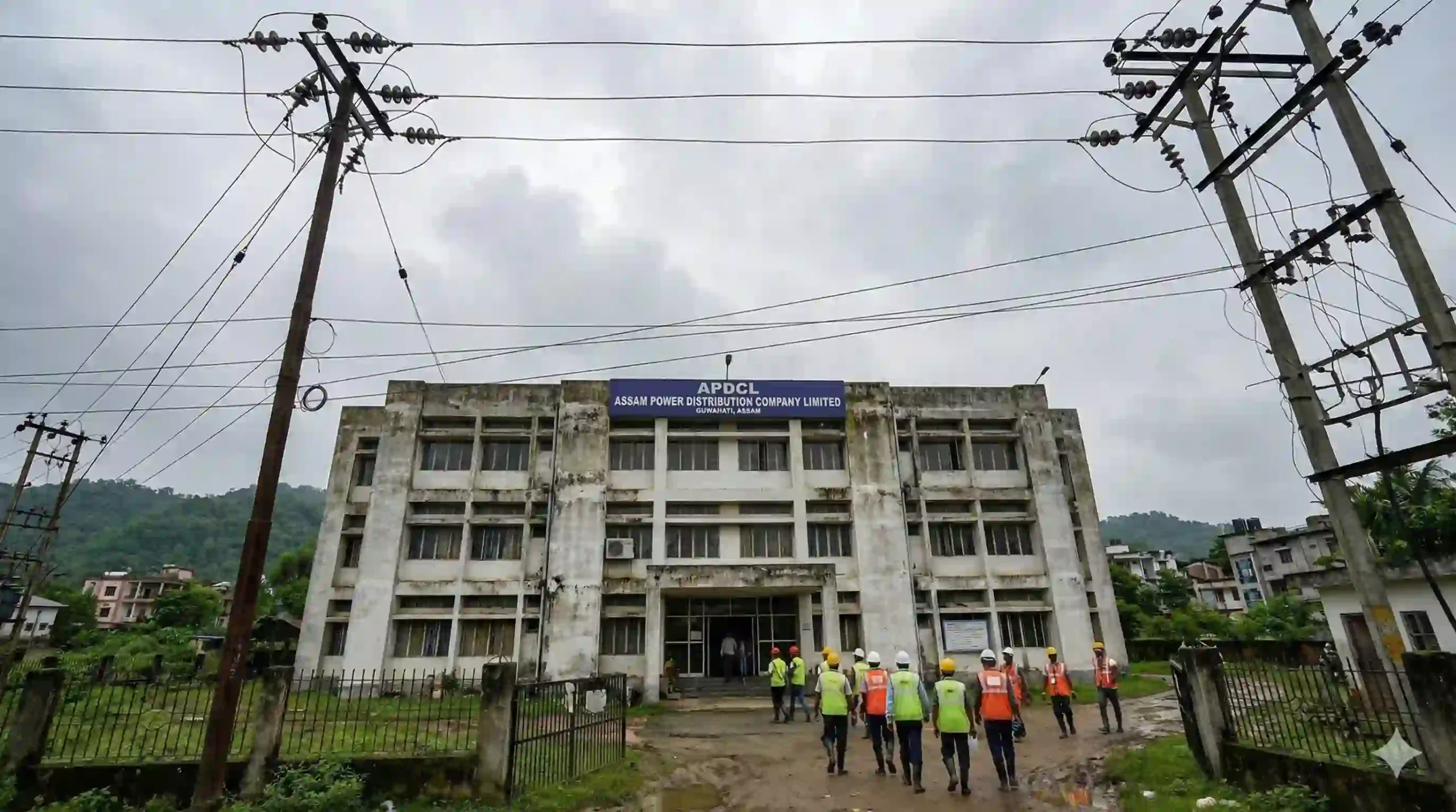 APDCL office building in Assam with power lines and staff in front